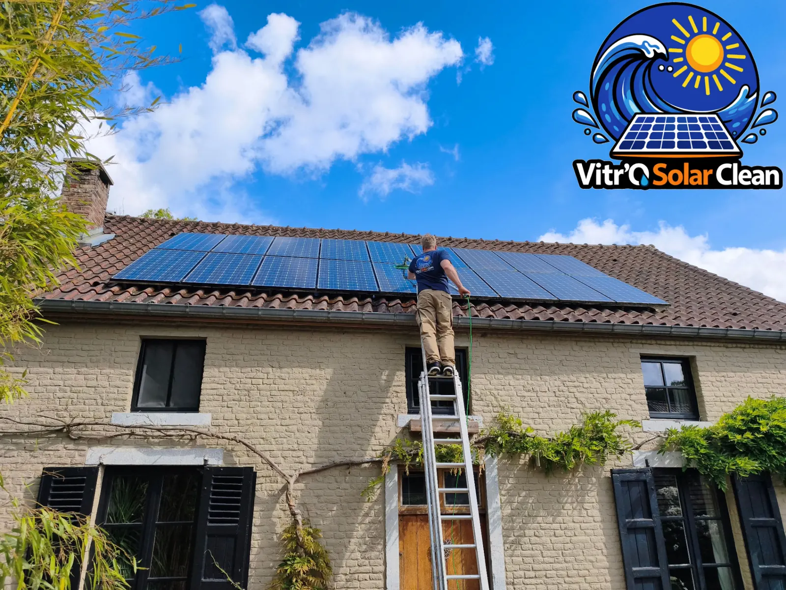 Technicien Vitro Solar Clean nettoyant des panneaux solaires à la perche eau pure depuis une échelle à Loverval (Hainaut)